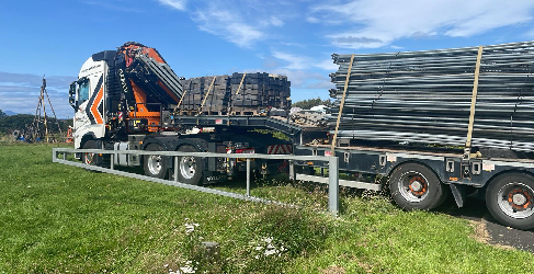 Lorry with herras fencing materials on the back.